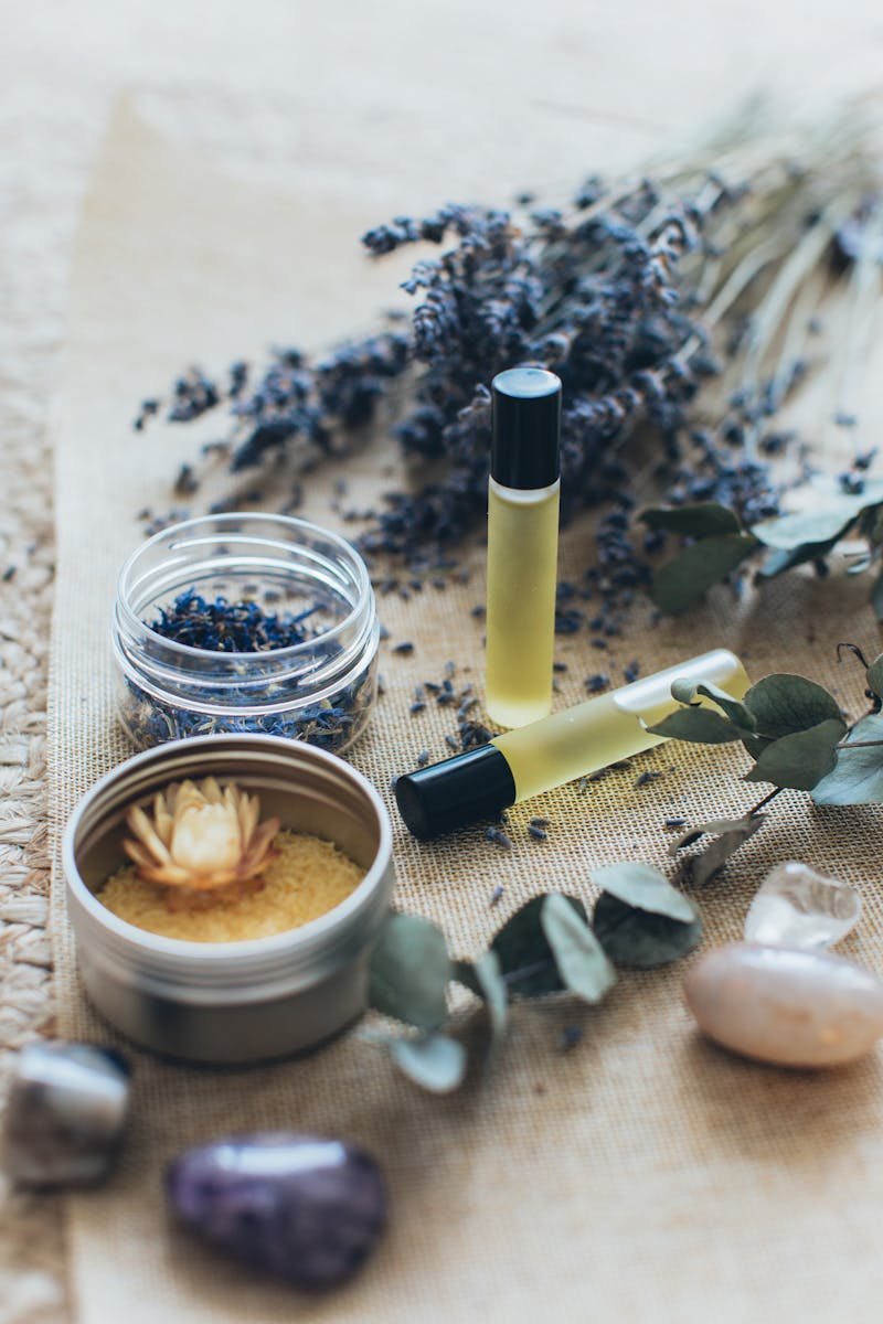 Essential oil roller bottles with dried lavender and eucalyptus on natural burlap
